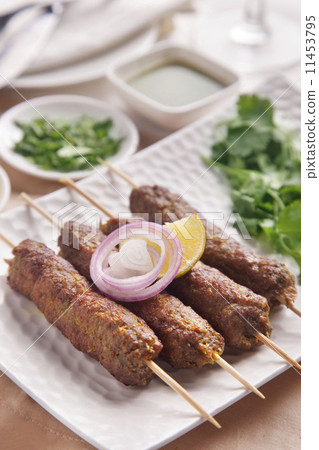 Seekh kabab garnished with onion and lime in plate 11453795