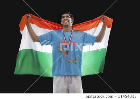 Hockey medalist with Indian flag looking up isolated over black background 11454315