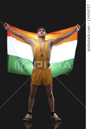 Proud young medalist with Indian flag standing against black background 11454317