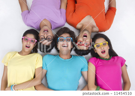 Directly above shot of surprise trendy friends lying over white background 11454510