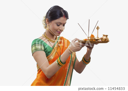 Maharashtrian woman praying while holding a puja thali Maharashtrian woman praying while holding a puja thali 11454833