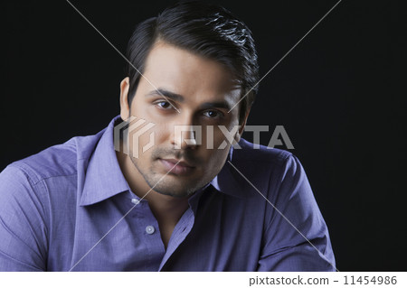 Close-up portrait of handsome Indian businessman over black background 11454986