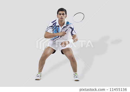 Full length of young man playing badminton isolated over white background 11455136