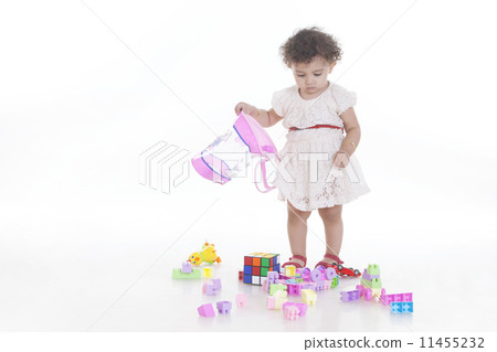 Full length of innocent cute girl looking at toys on floor against white background Full length of innocent cute girl looking at toys on floor against white background 11455232