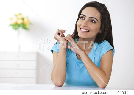 Smiling young woman looking away at home 11455303