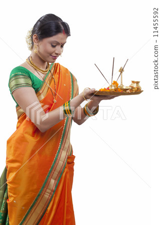 Maharashtrian woman praying while holding a puja thali 11455592