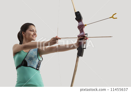 Young woman practicing archery isolated over gray background 11455637
