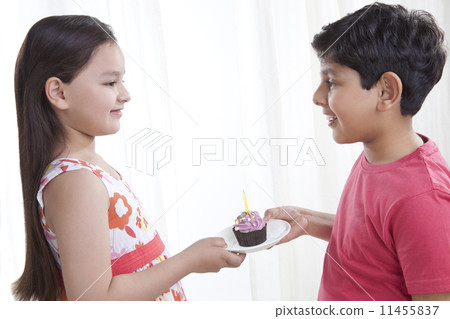Boy giving a cupcake to a girl 11455837