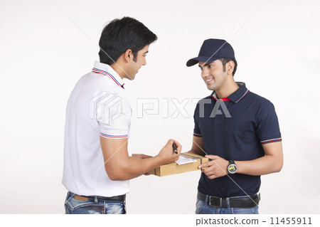 Smiling delivery man delivering package to customer against white background 11455911