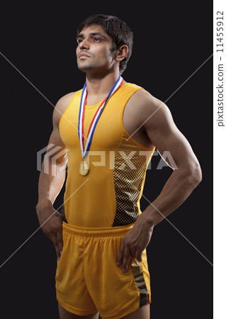 Male gold medalist standing with hands on waist over black background 11455912