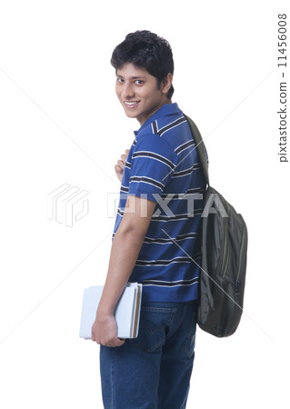 Side view portrait of smiling male student with books and rucksack over white background 11456008