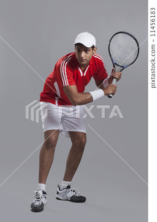 An Indian male tennis player playing over gray background 11456183