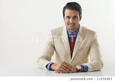 Portrait of confident Indian businessman sitting at office desk Portrait of confident Indian businessman sitting at office desk 11456461