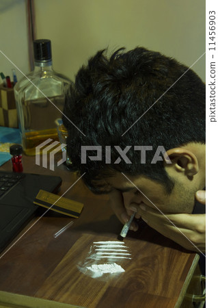Headshot of young man snorting drugs at home Headshot of young man snorting drugs at home 11456903
