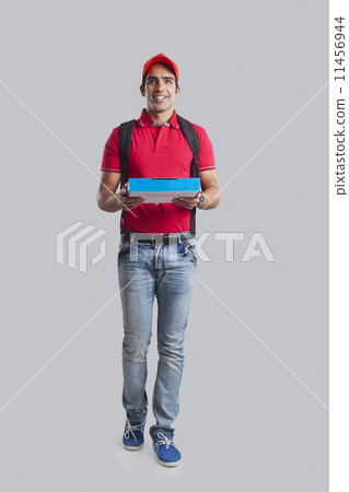 Full length of pizza delivery man against gray background 11456944