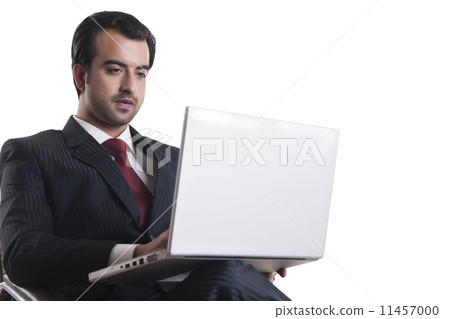 Young businessman using laptop over white background Young businessman using laptop over white background 11457000