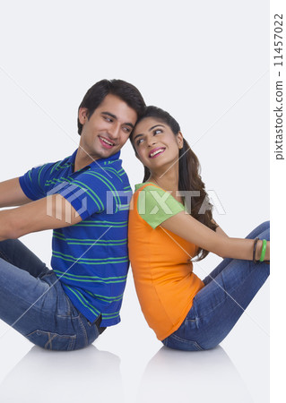 Loving young couple sitting back to back isolated on white background 11457022