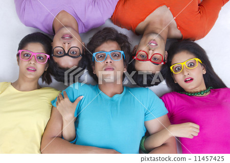 Directly above shot of surprise friends lying over white background Directly above shot of surprise friends lying over white background 11457425