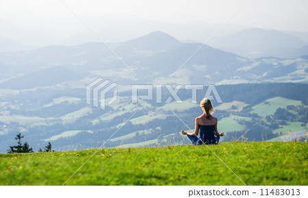 Young woman meditating outdoors Young woman meditating outdoors 11483013