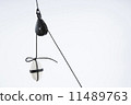 White stone, tied with dark rope, suspended with the use of a pulley.  11489763
