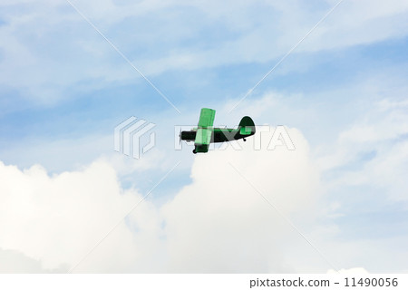small green agriculturial aircrafte flying in sky 11490056