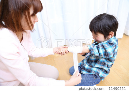 A boy wrapping a bandage in her arm 11490231