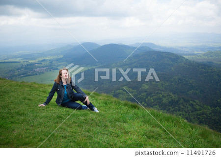 Girl sitting on the slope of volcano in Auvergne 11491726