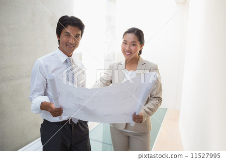 Estate agent looking at blueprint with potential buyer Estate agent looking at blueprint with potential buyer 11527995