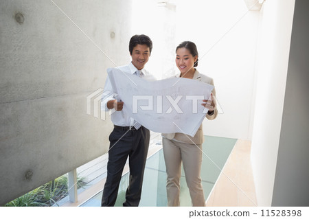 Estate agent looking at blueprint with potential buyer Estate agent looking at blueprint with potential buyer 11528398