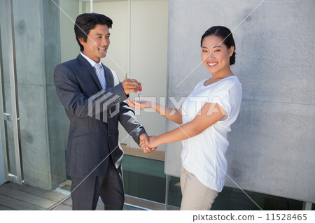 Estate agent giving house key to buyer Estate agent giving house key to buyer 11528465