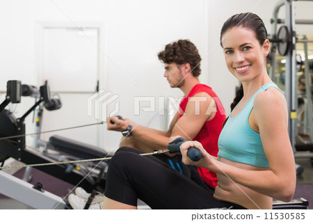 Smiling brunette working out on the rowing machine Smiling brunette working out on the rowing machine 11530585