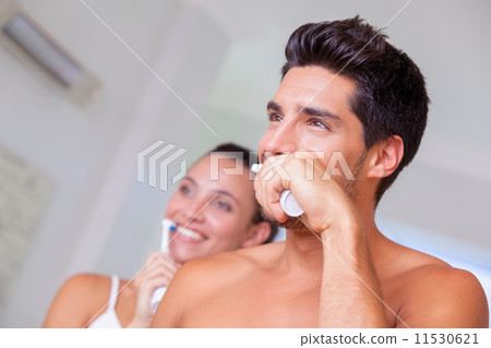 Attractive couple brushing their teeth in the morning 11530621
