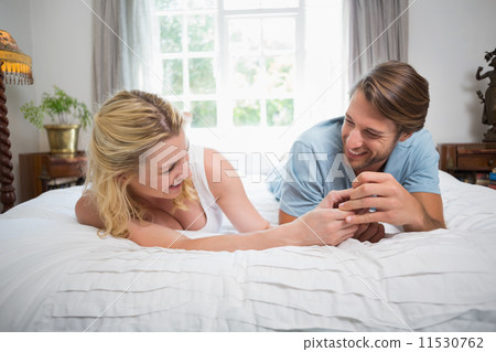 Cute couple relaxing on bed laughing together Cute couple relaxing on bed laughing together 11530762