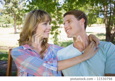 Cute couple sitting on bench in the park 11530798