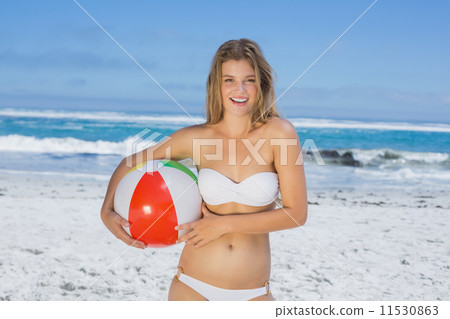 Smiling slim woman holding beach ball Smiling slim woman holding beach ball 11530863
