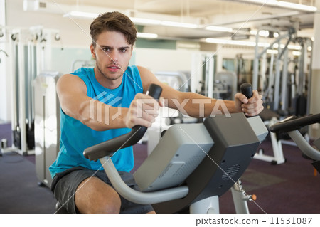 Focused man on the exercise bike Focused man on the exercise bike 11531087
