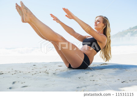 Fit blonde in core balance pilates pose on the beach Fit blonde in core balance pilates pose on the beach 11531115