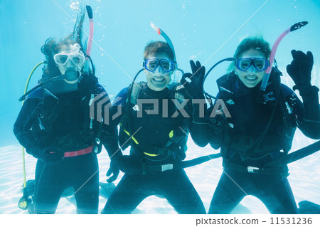 Friends on scuba training submerged in swimming pool making ok s Friends on scuba training submerged in swimming pool making ok s 11531236