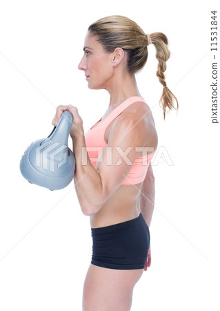 Female blonde crossfitter lifting kettlebell Female blonde crossfitter lifting kettlebell 11531844