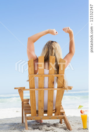 Pretty blonde sitting in deck chair with a cocktail Pretty blonde sitting in deck chair with a cocktail 11532347