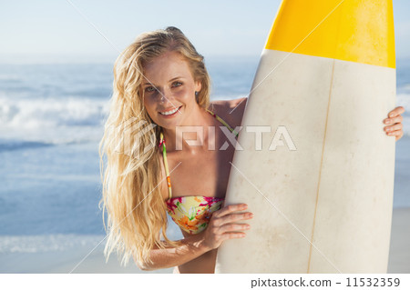 Gorgeous blonde surfer in bikini holding her board Gorgeous blonde surfer in bikini holding her board 11532359