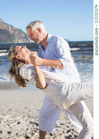 Happy couple dancing on the beach together Happy couple dancing on the beach together 11532374