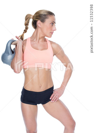 Female blonde crossfitter holding kettlebell Female blonde crossfitter holding kettlebell 11532398