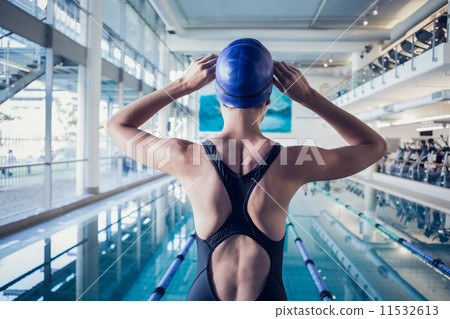 Fit swimmer standing by the pool 11532613