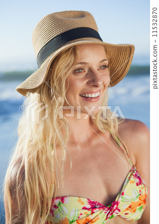 Gorgeous blonde in straw hat smiling on beach 11532870