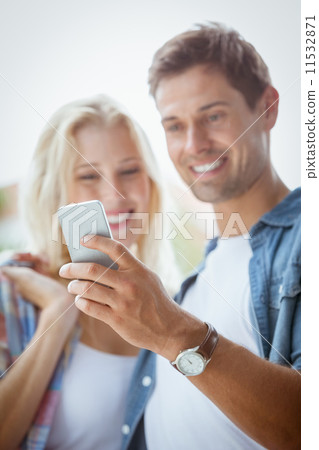 Cute young couple looking at smartphone together 11532871