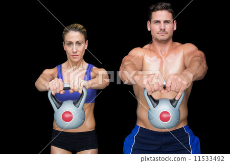 Crossfit couple posing with kettlebells Crossfit couple posing with kettlebells 11533492