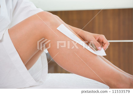 Woman waxing her legs herself 11533579