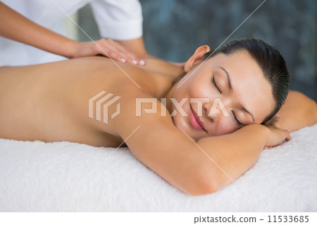 Smiling brunette enjoying a back massage Smiling brunette enjoying a back massage 11533685