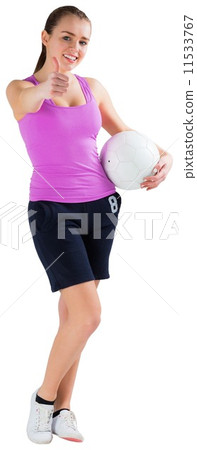 Fit brunette holding ball showing thumbs up Fit brunette holding ball showing thumbs up 11533767